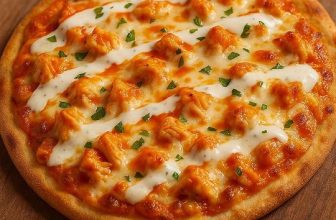 Buffalo chicken flatbread pizza with melted cheese, ranch drizzle, and spicy buffalo sauce on crispy naan crust.