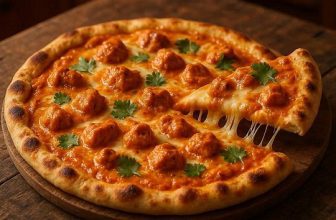 Butter Chicken Pizza topped with creamy curry sauce, mozzarella cheese, and cilantro on a naan-style crust.
